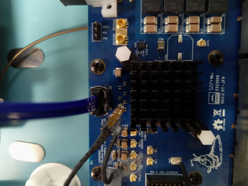 Closeup of differential probe tip soldered across a pair of AC coupling capacitors