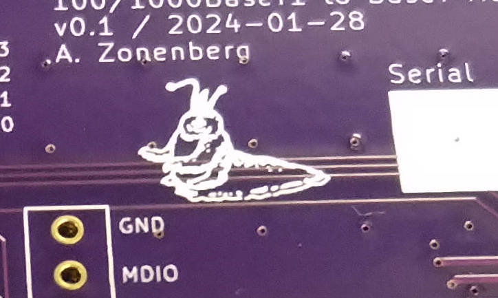 Photo of purple PCB with a white silkscreen drawing of a slug-like creature on it